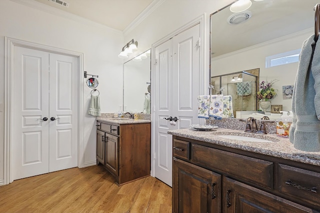 bathroom featuring vanity, an enclosed shower, wood-type flooring, and crown molding