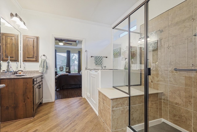 bathroom with vanity, a shower with door, crown molding, ceiling fan, and wood-type flooring