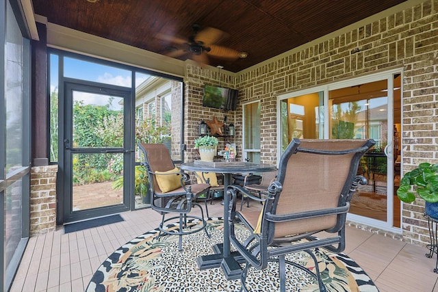 sunroom with ceiling fan and wooden ceiling