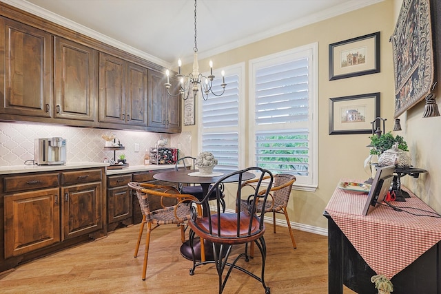 dining space featuring a chandelier, light hardwood / wood-style floors, and ornamental molding