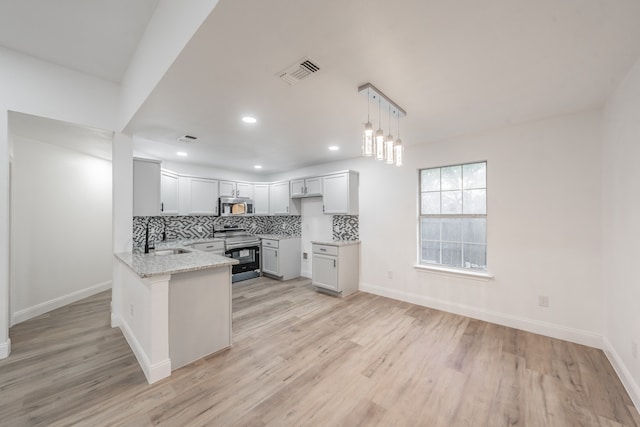 kitchen featuring light stone countertops, appliances with stainless steel finishes, and light hardwood / wood-style flooring