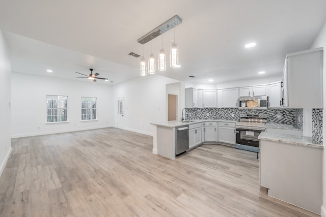 kitchen with kitchen peninsula, white cabinetry, stainless steel appliances, and light wood-type flooring