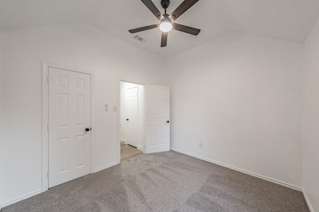 unfurnished bedroom featuring ceiling fan, light carpet, and vaulted ceiling