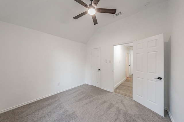 carpeted empty room featuring ceiling fan and lofted ceiling