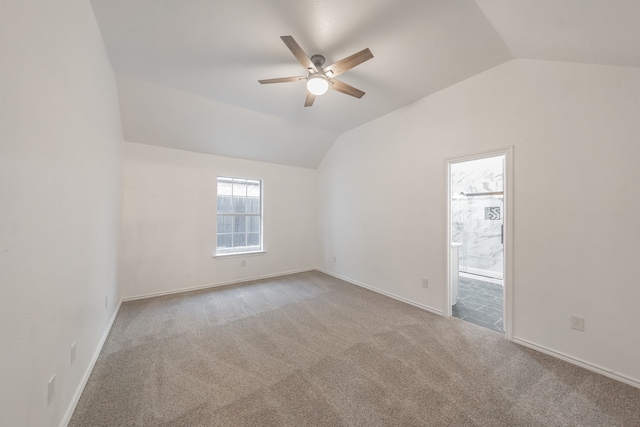 carpeted spare room featuring ceiling fan and lofted ceiling