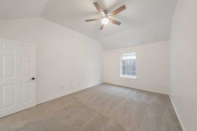 carpeted empty room featuring ceiling fan and lofted ceiling