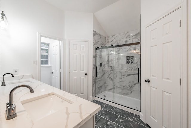 bathroom with vanity, vaulted ceiling, and walk in shower