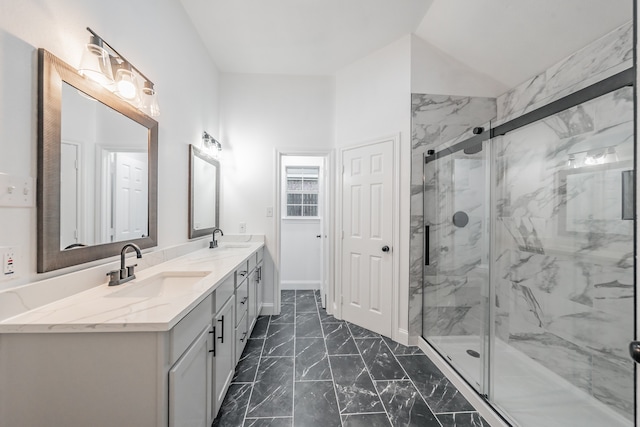 bathroom featuring a shower with door and vanity