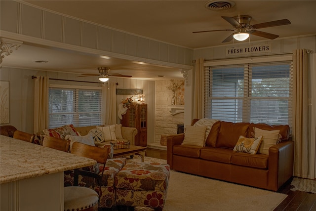 living room featuring ceiling fan, wood-type flooring, and ornamental molding