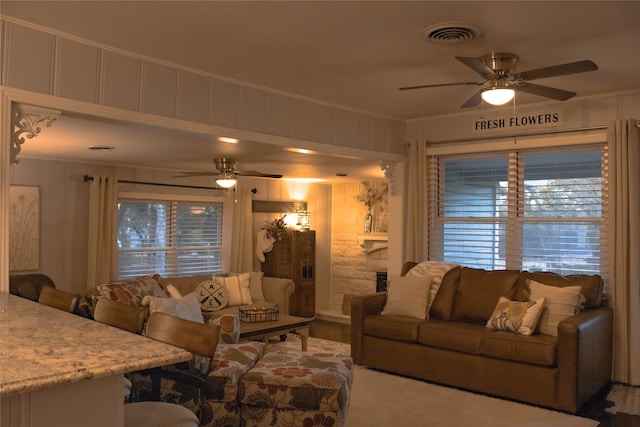 living room with plenty of natural light, crown molding, and ceiling fan