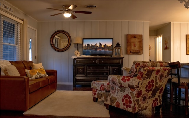 living room with ceiling fan, crown molding, and dark wood-type flooring