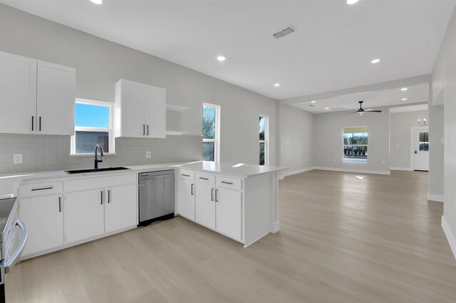 kitchen featuring light wood-type flooring, white cabinetry, stainless steel dishwasher, and ceiling fan