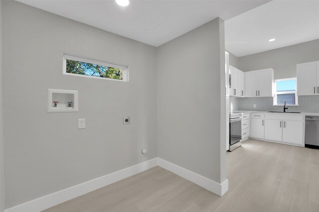 laundry area featuring gas dryer hookup, sink, hookup for a washing machine, light wood-type flooring, and hookup for an electric dryer