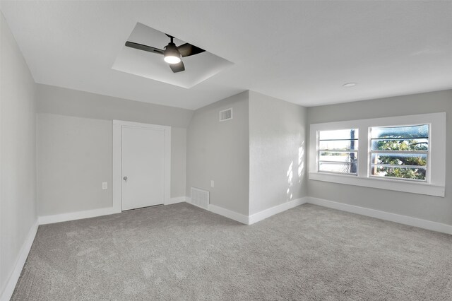 additional living space with ceiling fan and light colored carpet