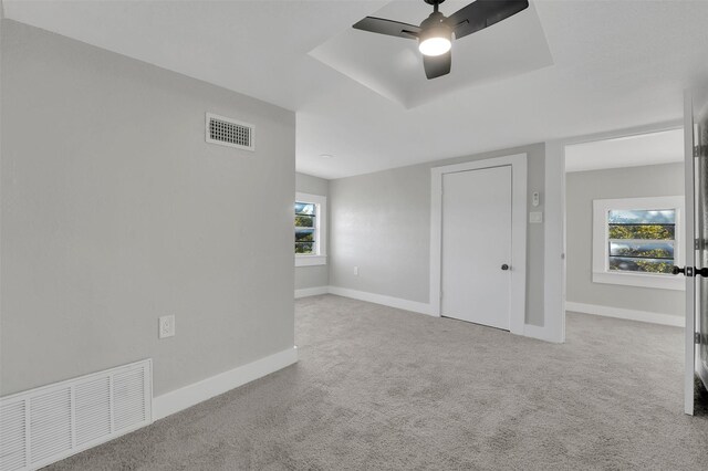 carpeted empty room with plenty of natural light and ceiling fan