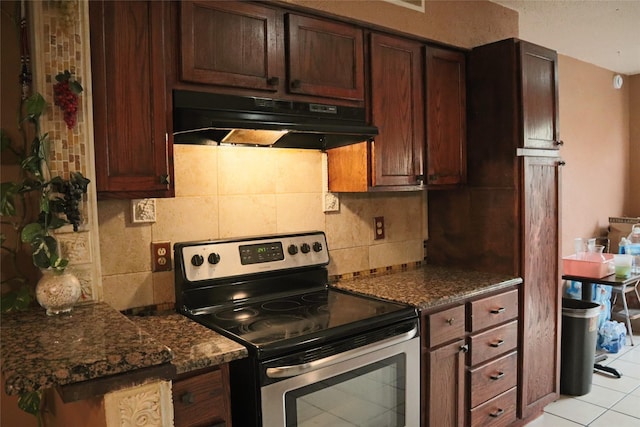 kitchen with tasteful backsplash, dark stone countertops, stainless steel electric range, dark brown cabinets, and light tile patterned floors