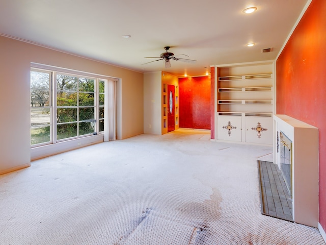 unfurnished living room featuring light carpet, crown molding, and ceiling fan