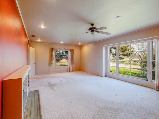 unfurnished living room featuring light carpet, ceiling fan, and ornamental molding