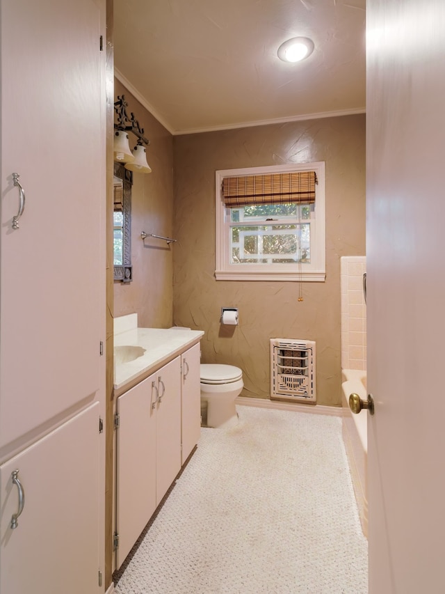 bathroom with heating unit, crown molding, vanity, and toilet