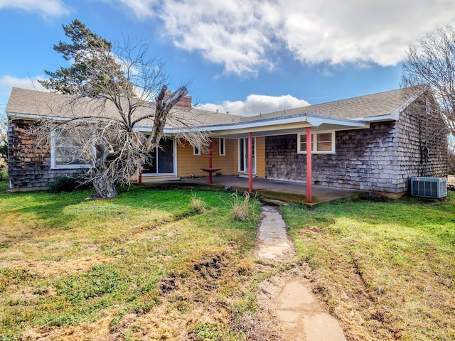 rear view of property featuring a lawn, a patio area, and central AC unit