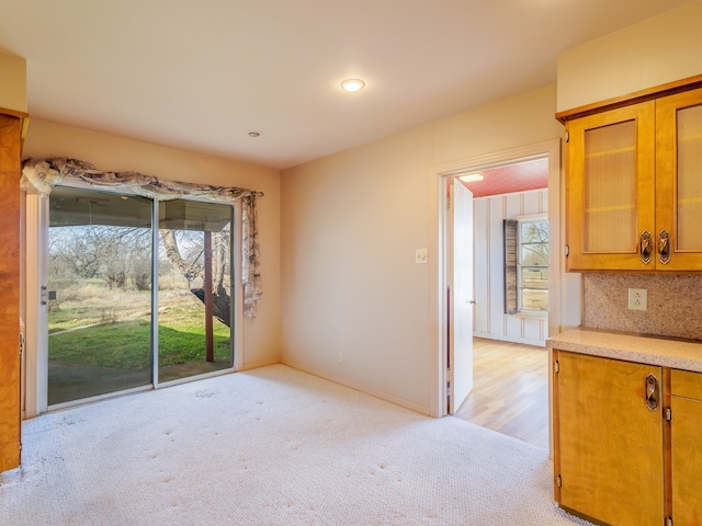 unfurnished dining area featuring light colored carpet