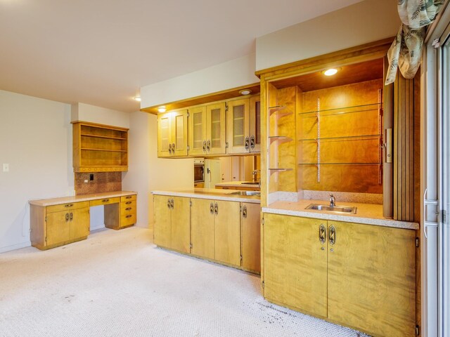 kitchen featuring decorative backsplash, light carpet, stainless steel oven, and sink