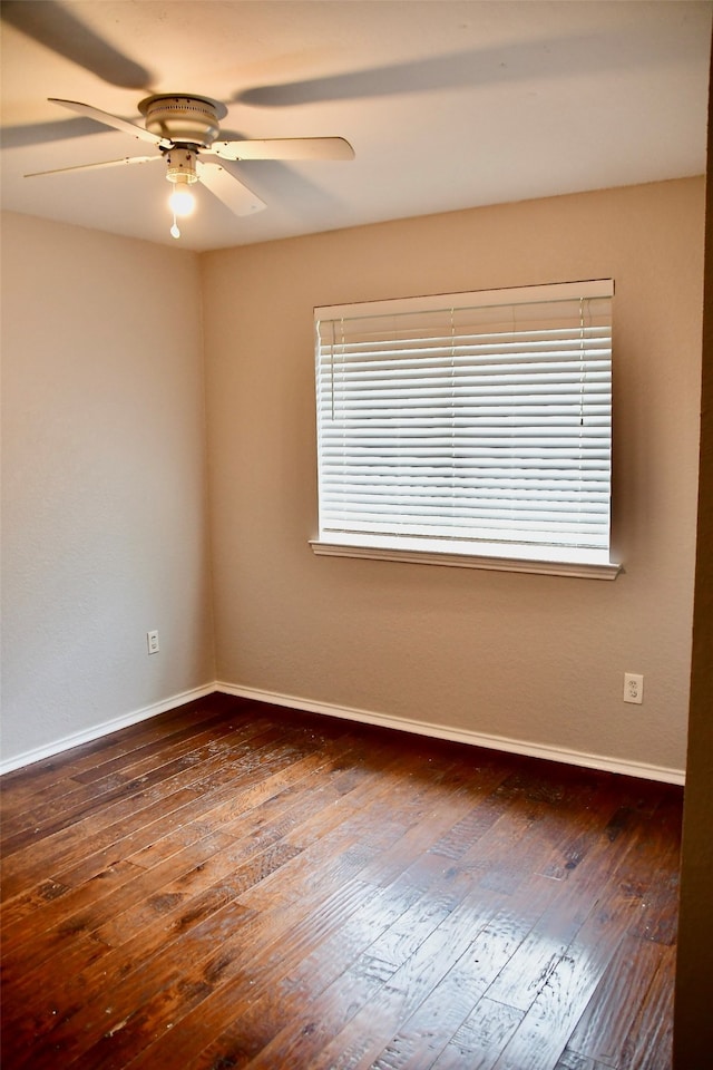 empty room with ceiling fan and dark hardwood / wood-style flooring