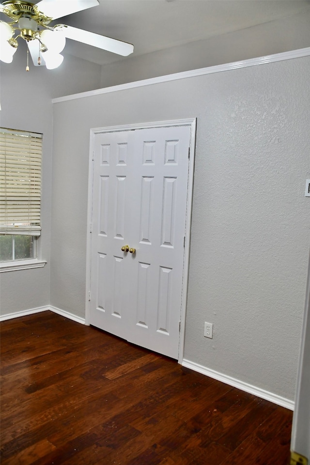 empty room with dark hardwood / wood-style floors and ceiling fan