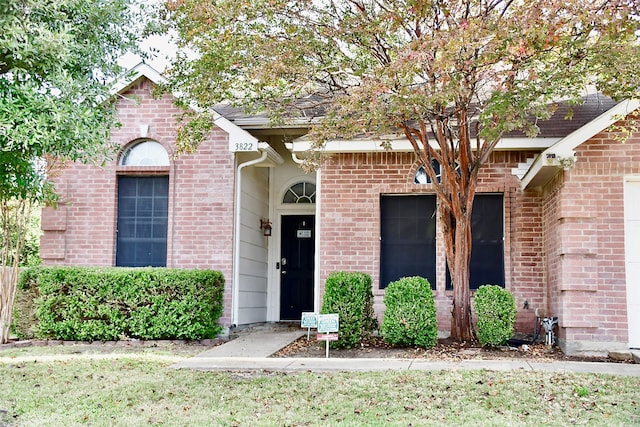 entrance to property featuring a yard