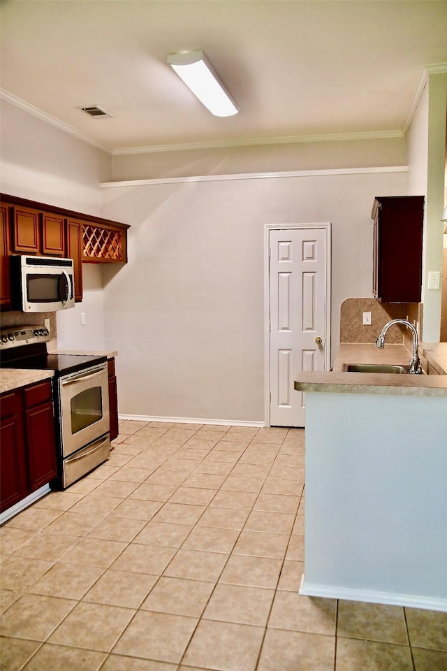 kitchen with backsplash, light tile patterned floors, sink, and appliances with stainless steel finishes