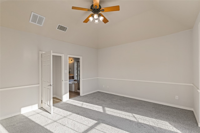 unfurnished bedroom featuring light carpet, connected bathroom, vaulted ceiling, and ceiling fan