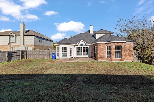 back of house with a yard and a patio