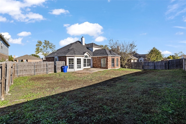 back of property featuring a lawn and a patio