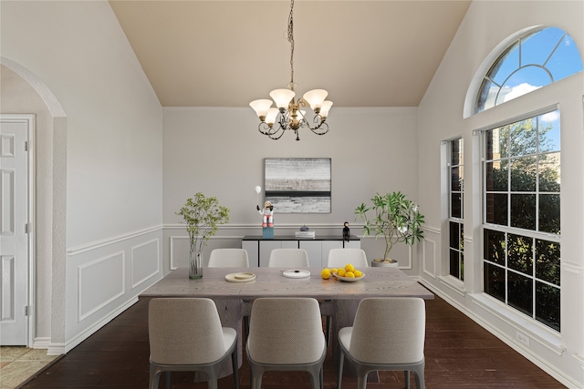 dining space with a chandelier, dark hardwood / wood-style floors, and vaulted ceiling