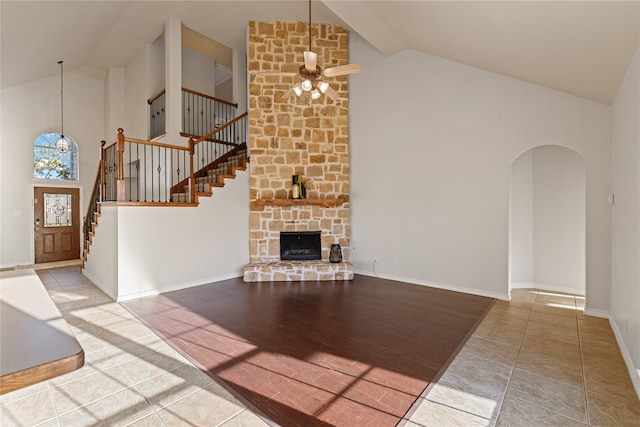 unfurnished living room with a fireplace, hardwood / wood-style floors, high vaulted ceiling, and ceiling fan