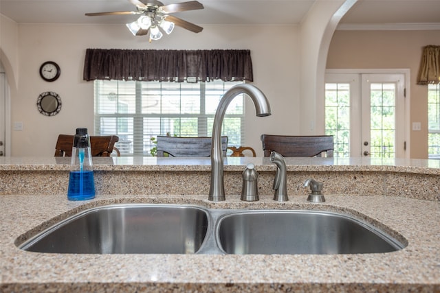 kitchen with french doors, sink, ceiling fan, light stone countertops, and ornamental molding