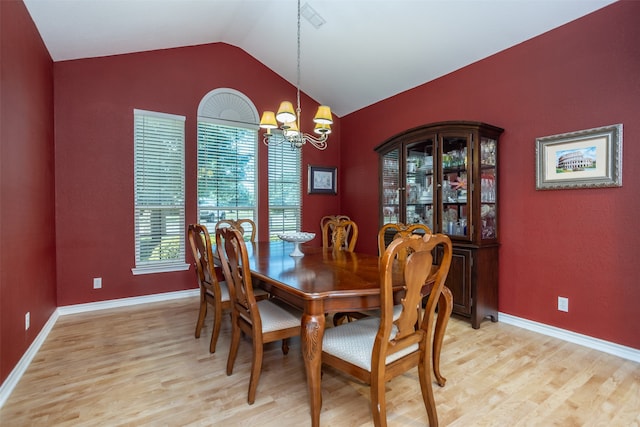 dining area featuring light hardwood / wood-style flooring, lofted ceiling, and an inviting chandelier