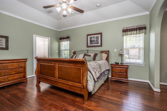 bedroom featuring a tray ceiling, multiple windows, ceiling fan, and dark wood-type flooring