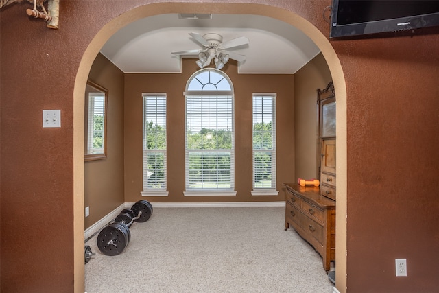 interior space with light carpet and ceiling fan