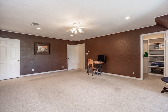 carpeted home office with ceiling fan