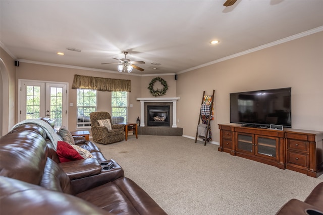 carpeted living room with a fireplace, ceiling fan, crown molding, and french doors