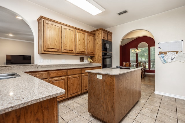 kitchen featuring an inviting chandelier, black appliances, ornamental molding, light tile patterned floors, and a kitchen island