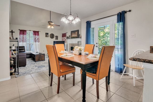 dining room featuring vaulted ceiling, ceiling fan with notable chandelier, and light tile patterned floors