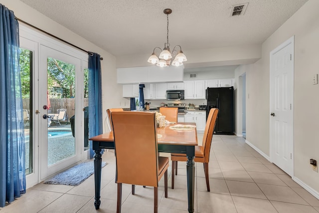 tiled dining area featuring a notable chandelier and a textured ceiling