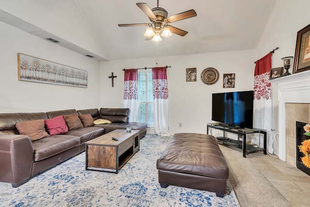 carpeted living room featuring ceiling fan, lofted ceiling, and a tile fireplace