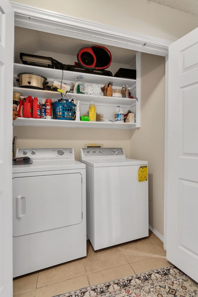 laundry room featuring washing machine and dryer and light tile patterned floors