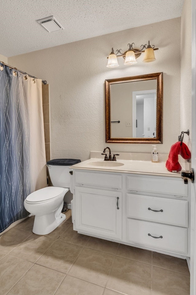 bathroom featuring a shower with shower curtain, vanity, a textured ceiling, tile patterned floors, and toilet