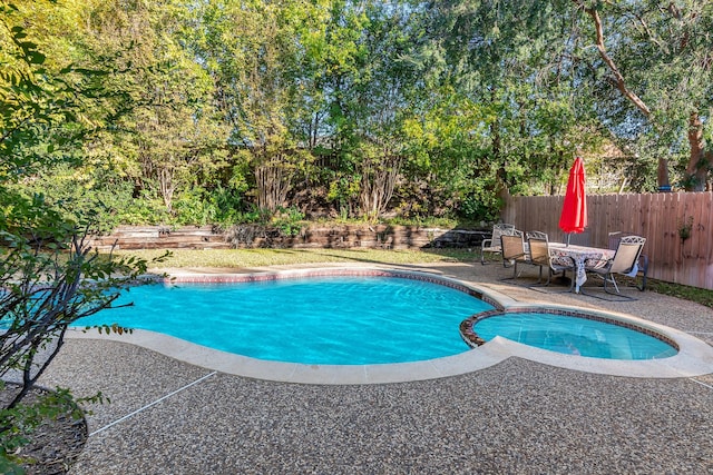 view of pool featuring an in ground hot tub and a patio