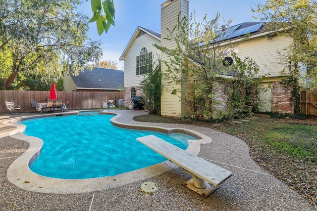 view of pool featuring a diving board, an in ground hot tub, and a patio