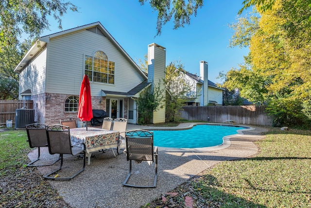 view of swimming pool with central air condition unit and a patio